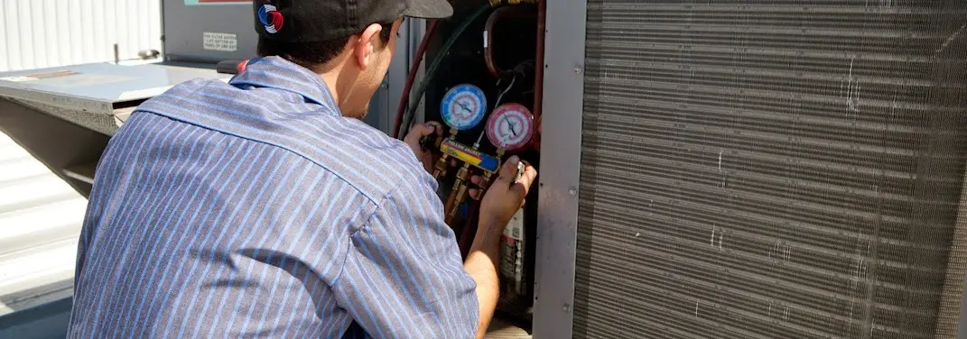 HVAC technician servicing a condenser unit in North Star