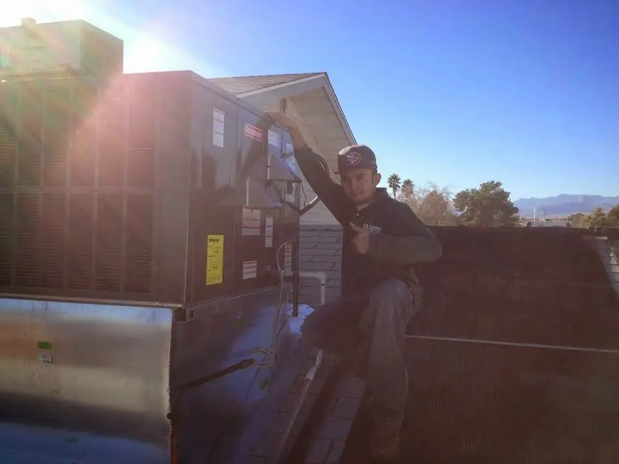 HVAC technician performing Air Duct Cleaning on a rooftop unit in North Star